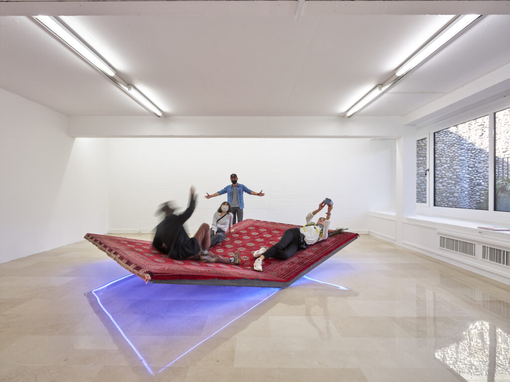 Personnes installées sur un tapis surélevé et éclairé