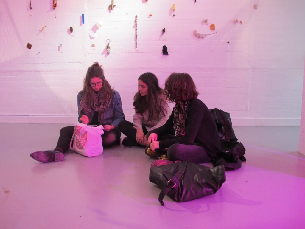 3 visiteuses sont assises au sol