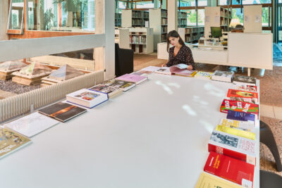 Etudiante consultant la table de nouveautés à la bibliothèque