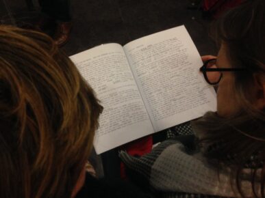 aperçu des pages d'un livre vues par dessus de deux personnes ne train de le lire