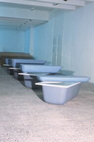 baignoires en plastique bleu disposées au sol avec une deuxième posé dessus