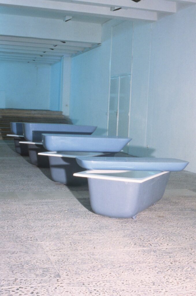 baignoires en plastique bleu disposées au sol avec une deuxième posé dessus