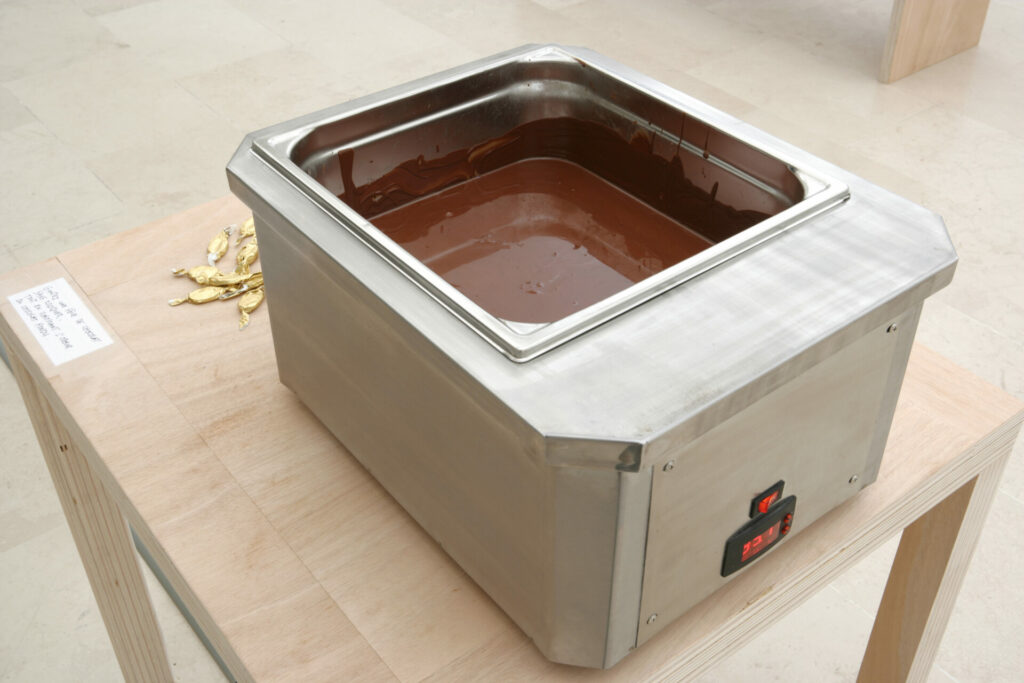 chocolat en fèves, bain-marie, table et bancs en bois