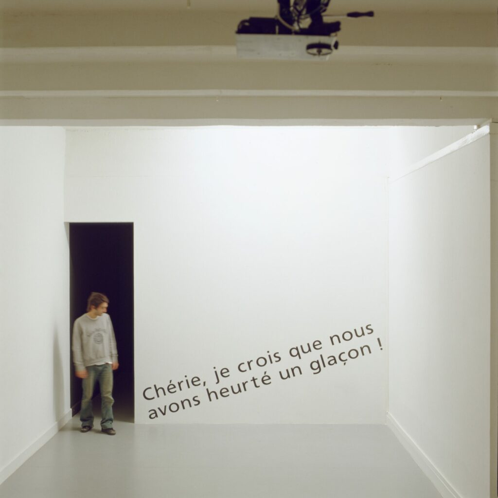 poster, caméra, 3 moniteurs vidéo, 2 vidéo-projections, lettres vinyle sur mur, affiches-cigarettes